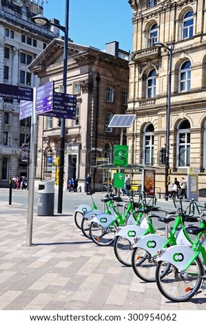 LIVERPOOL, UNITED KINGDOM - JUNE 11, 2015 - Tourist sights signpost in Derby Square on the Corner of James Street with City hire bikes in the foreground, Liverpool, England, UK, June 11, 2015.