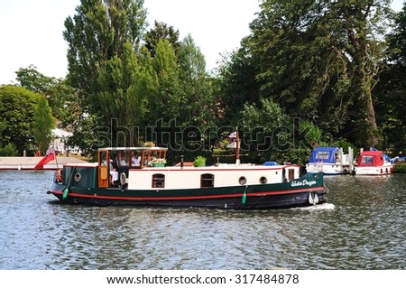 HENLEY-ON-THAMES, UK - JULY 10, 2015 - Thames houseboat sailing along the River Thames, Henley-on-Thames, Oxfordshire, England, UK, Western Europe, July 10, 2015.