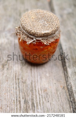 Canning vegetables in the bank on wooden background