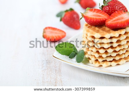 Waffles, mint and ripe strawberries. Delicious summer dessert.