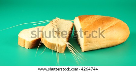 A long loaf of bread and an ear on a green background.