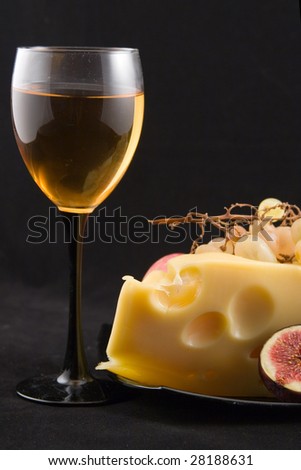 wine, cheese and fruits on a black background