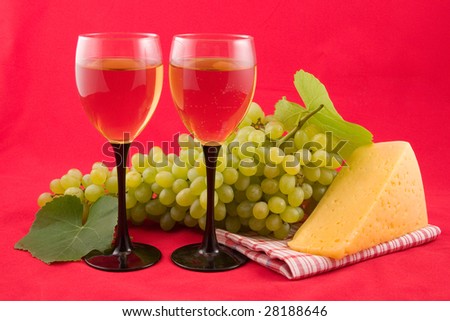 wine, cheese and fruits on a red background