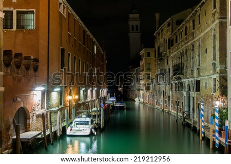 A small canal at night in Venice, Italy.