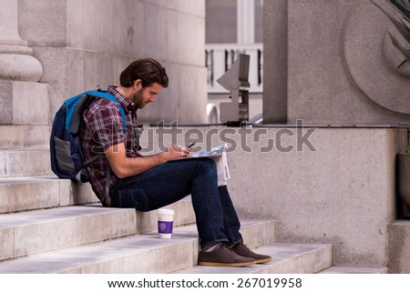 SAN FRANCISCO, CA - April 4, 2015 - Young man sitting on the steps of the former Pacific Stock Exchange building in San Francisco.