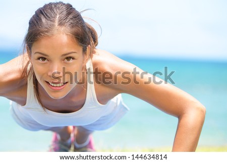 Sport fitness woman training push-ups. Female athlete exercising push up outside in sunny sunshine. Fit girl fitness model in crossfit exercise outdoors. Healthy lifestyle concept.