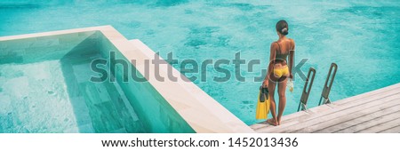 Luxury Bora Bora resort woman going snorkeling from overwater bungalow panoramic. Tahiti paradise destination vacation. 商業照片 © 