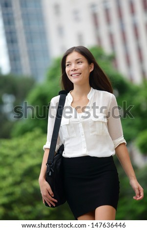 Business woman walking casual outdoor in Hong Kong. Asian businessperson office worker holding briefcase.. Young multiracial Chinese Asian / Caucasian female professional in central Hong Kong.