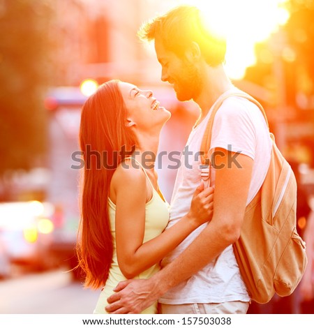 Couple in love kissing laughing having fun. Dating interracial young couple embracing on date. Caucasian man, Asian woman on Manhattan, New York City, USA.