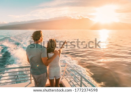 Cruise ship vacation travel tourists couple watching sunset on deck summer travel. lady pointing at sun to man tourist relaxing on Caribbean holidays.
