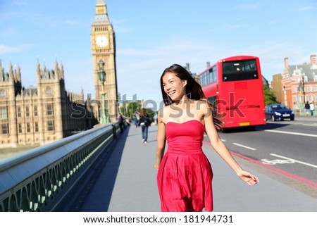 London woman happy walking by Big Ben, England. Tourist on Europe travel sightseeing running in joy by red double decker bus, Westminster Bridge, London, England