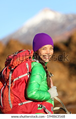 Hiking woman hiker living healthy lifestyle hiking outdoors wearing backpack smiling happy. Beautiful female trekking with looking with aspirations. Mixed race Asian Caucasian girl in her 20s.