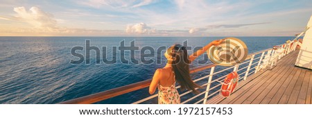 Happy cruise woman relaxing on deck feeling free watching sunset from ship on Caribbean travel vacation. Panoramic banner of sea and boat.