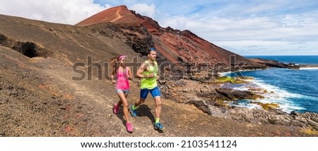 Trail running couple of triathletes runners doing hiit cardio workout outside banner. Two athletes training on coast lansdcape for marathon. Outdoor active people long distance panoramic. Foto d'archivio © 