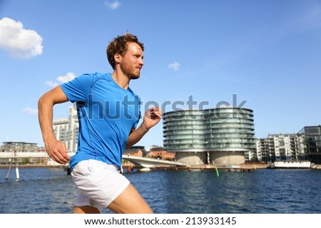 Runner running in urban Copenhagen city. Man exercising jogging in downtown, Bryggen, Copenhagen, Denmark.