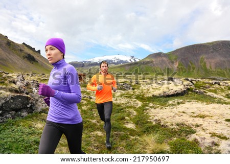 Trail running people in cross country run. Woman and man runners training jogging outdoors in beautiful mountain nature landscape on Snaefellsnes, Iceland.