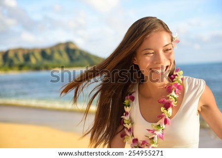 Hawaii beach woman happy on Hawaiian holidays. Portrait of cheerful young Asian adult laughing of fun during her travel summer vacation in Waikiki beach, Honolulu, Oahu, Hawaii, USA.
