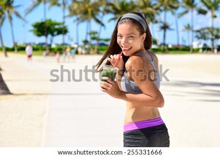 Green detox cleanse vegetable smoothie woman. Healthy sport woman runner drinking fresh and happy after running. Fitness and healthy lifestyle concept with multicultural Asian Caucasian female model.