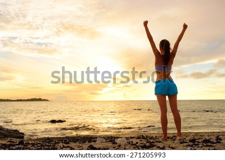 Freedom winning woman cheering at sunset beach. Success concept with female adult from the back arms up at the sky looking at the ocean feeling free and successful. Achievement of her life.