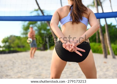 Beach volleyball woman player giving hand sign signal for play. Female athlete playing beach volley ball sport outdoors in summer in sports bikini. Healthy active lifestyle concept.