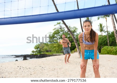 Beach volleyball serve - man serving in beach volley ball game on beautiful summer day. Young people having fun in the sun living healthy active sports lifestyle outdoors. Woman and man.