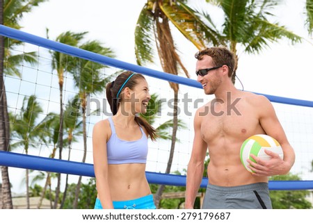 Beach volleyball. People playing having fun in sporty active lifestyle portrait holding volley ball after game in summer. Woman and man fitness model living healthy lifestyle doing sport on beach.
