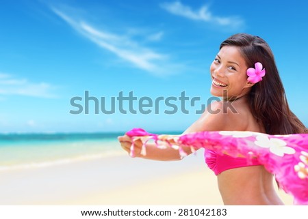 Beach woman in bikini happy on vacation paradise beach waving scarf sarong in wind happy in on travel holiday in tropical Hawaii an beach. Beautiful biracial Asian Caucasian girl.