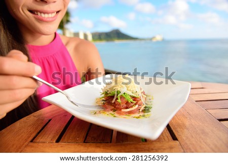 Tuna tartare. Raw ahi, Hawaiian food. Woman eating dish on Waikiki, Oahu, Hawaii.