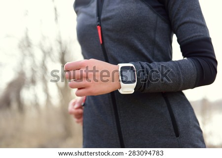 Smartwatch woman running with heart rate monitor. Closeup of female wrist wearing smart sport watch as activity tracker outdoors during cardio workout.