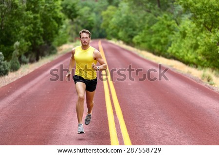 Running man runner sprinting for fitness and health. Young male athlete in sprint run wearing sports running shoes and shorts in workout for marathon. Full body length view of sprinter.