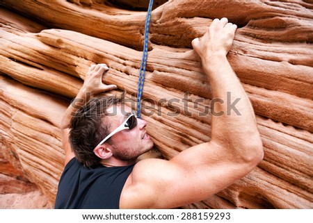 Climber man climbing on rock. Male athlete rock climbing.