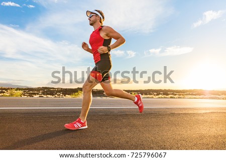 Triathlon - Triathlete man running in triathlon suit training for ironman race. Male runner exercising on Big Island Hawaii. Sunset. Foto d'archivio © 
