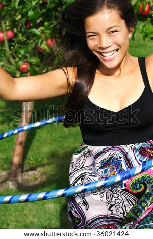 Hula hoop. Beautiful young woman having fun doing hula hoop outdoors in the fall