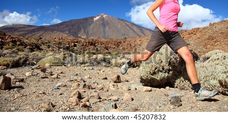 Running in spectacular volcano landscape on Teide, Tenerife. Woman in pink top.