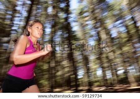 Running, Female runner running fast at great speed in forest. Motion blurred image of beautiful Asian / Caucasian woman athlete sprinting outdoors in tank top.