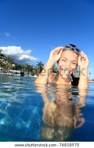Pool woman on holidays in tropical resort swimming. Beautiful girl smiling with goggles. Asian Caucasian young woman model.