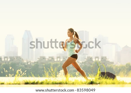 Running in city park. Woman runner outside jogging with Montreal skyline in background