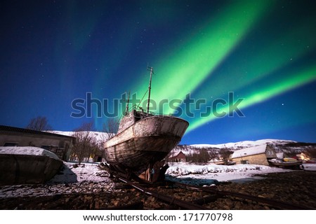 Old ship on the background of the Northern Lights in Tromso, Norway
