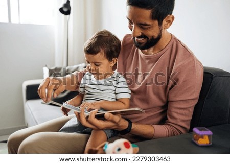 Similar – Image, Stock Photo Father and son reading book together