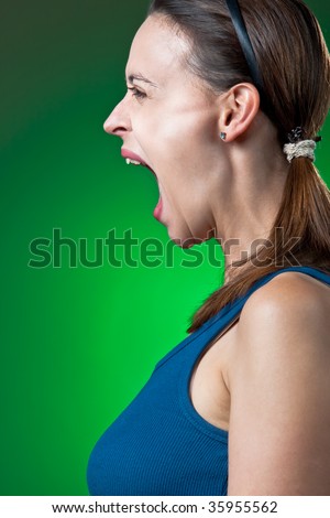 A young woman screaming dramatically in profile.