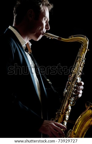 A smartly dressed saxophone player in a dark club setting