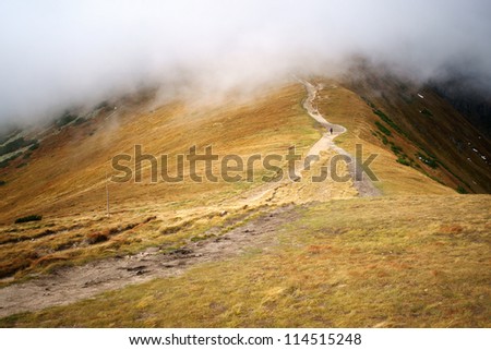 Man alone going ahead in the clouds in the mountains