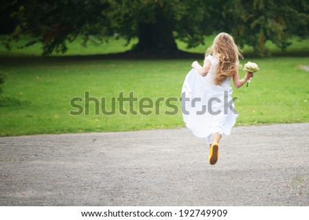 Young girl is running away in park.
