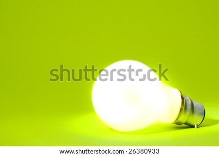 Illuminated light bulb on green implying green energy