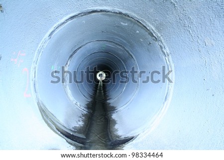 A storm drain underground shows the light at the end of the tunnel