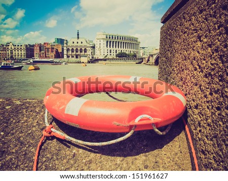 Vintage looking A life buoy on River Thames bank, London
