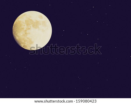 Vintage looking Full moon over dark sky with stars
