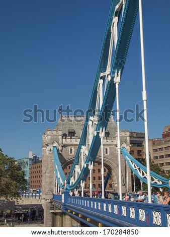 LONDON, ENGLAND, UK - SEPTEMBER 07, 2012: Tourists crossing Tower Bridge on River Thames linking the Tower of London to the South Bank