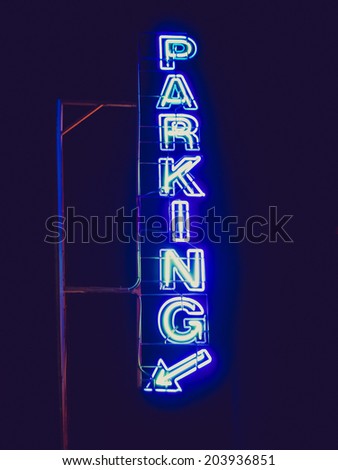 Vintage retro looking Parking sign neon light at night over dark sky