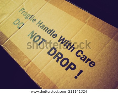 Vintage retro looking Fragile Handle with Care Do not drop label on a corrugated cardboard box